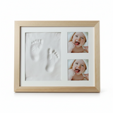 A light natural wood framed baby keepsake photo frame with a white mat.