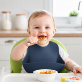 Baby Wearing a Deep Blue Silicone Bib at Mealtime