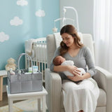 Woman holding a baby in a nursery with a crib and baby items.
